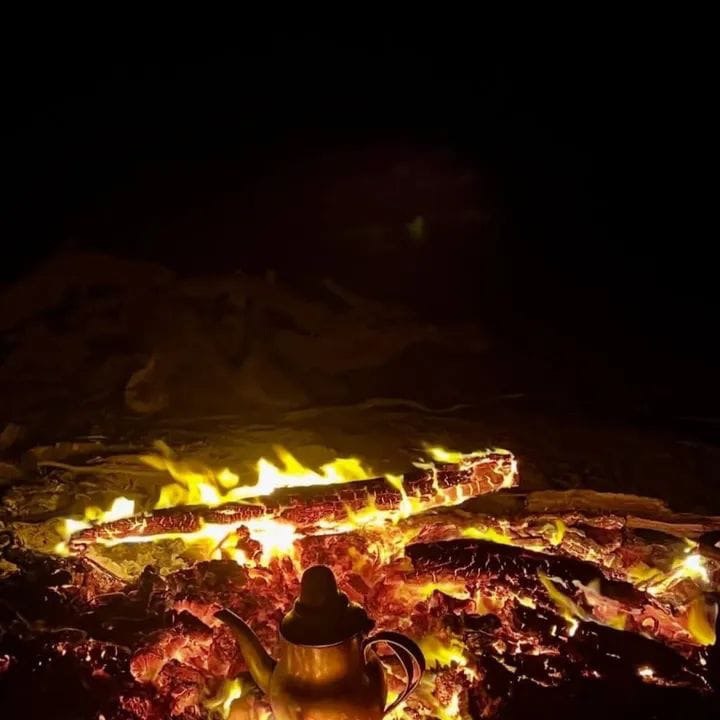 Campfire with teapot under the desert sky